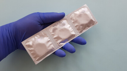 condom in hand. hands in medical gloves and with a condom. safe sex