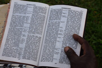 Swahili Bible with hand and finger on the bible from an african men