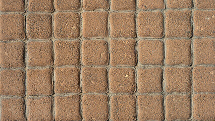 Fragment of brown paving stones on the pedestrian sidewalk