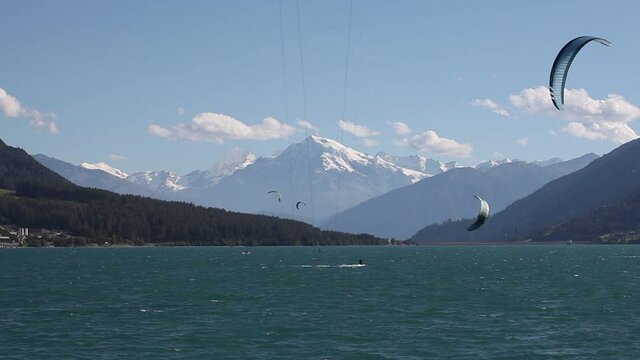 Panorama on Lake Resia - Reschensee, with kitesurfers and glaciers of Mount Ortles in the background, South Tyrol, Italy