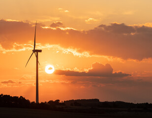 wind turbine during sunset under partly cloudy skies