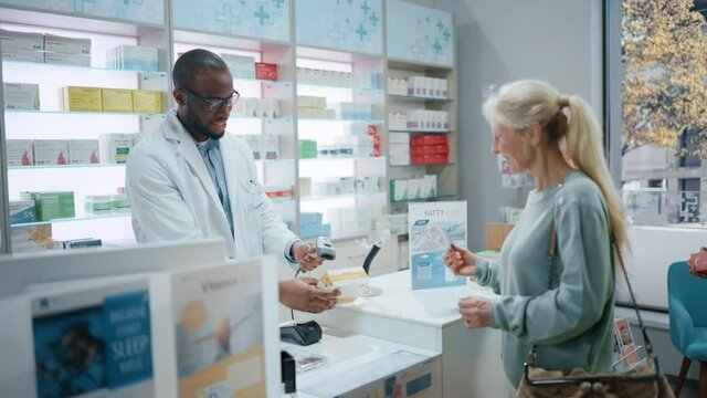 Pharmacy Drugstore Checkout Counter: Professional Black Pharmacist Provides Best Customer Service to Diverse Group of Multi-Ethnic Clients Buying Medicine Paying with Contactless Payment Credit Cards