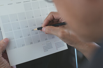 Business man planning his work schedule on calendar  event planner, timetable in office