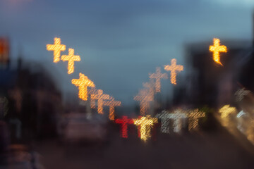 City lights are blurry, with a cross-shaped bokeh background.car on the road at night,cross symbol.