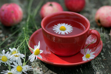 cup of tea, red apples and flowers
