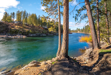 The Spokane River with an upscale water view home on the hills above, seen from Corbin Park in Post Falls, Idaho, USA