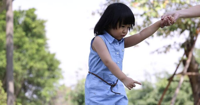 4K Video Slow motion Asian mom and little daughter hold hand walking in the park. Concept for family relationship and relaxing time.