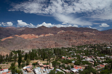 Fototapeta na wymiar Tilcara village at the foot of Humahuaca ravine. Panorama view of the colorful mountains and buildings under a beautiful sky with clouds.