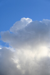 Dramatic and glowing cloudscape of blue sky and white and gray clouds as a nature background
