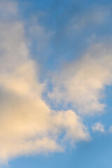 Late afternoon cloudscape, glowing clouds against a blue sky, as a nature background
