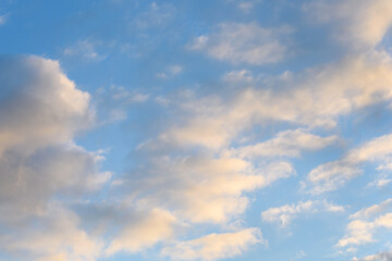 Fototapeta premium Late afternoon cloudscape, glowing clouds against a blue sky, as a nature background 