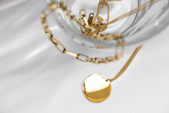 Closeup of a golden necklace with a round circle pendant