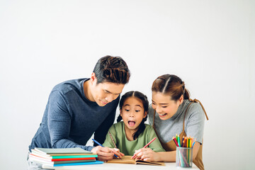 Portrait enjoy happy smiling love asian family father and mother with little asian girl learning and writing in book with pencil making homework at home.Education concept