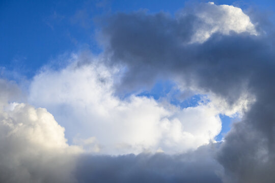 Dramatic and glowing cloudscape of blue sky and white and gray clouds as a nature background © knelson20