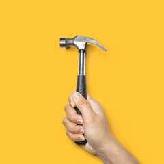 Person holding a small hammer with a black handle, hammer is a tool for hammer nails, Isolated on yellow background and clipping path.