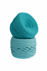 Blue cotton yarn for knitting on a white background.
