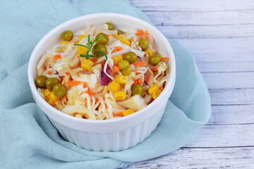 Salad of fresh cabbage with green peas and corn.
