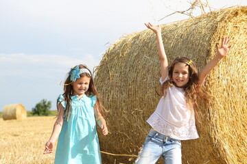 Two little girls playing in a wheat field