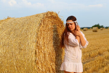 Naklejka na ściany i meble Girl in a yellow dress in a wheat field