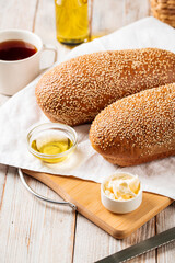 Side view on loafs of wheat and rye flour bread with butter on the wooden background