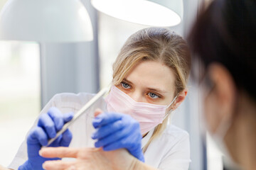 Professional manicure. Closeup shot of a woman in a nail salon. Professional nail polish with electric tips.