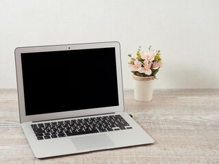 Cropped shot of a portable office desk with mock-ups of computer devices, supplies, and decorations on a wooden desk