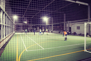 夜の屋上、フットサルコートのプレイヤーたち