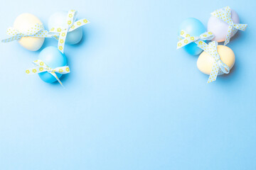 Easter flat. Colorful egg with tape ribbon on pastel blue background in Happy Easter decoration. Spring holiday top view concept.