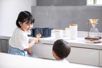 白いキッチンで女の子が青い鍋で料理をしている　girl kitchen 