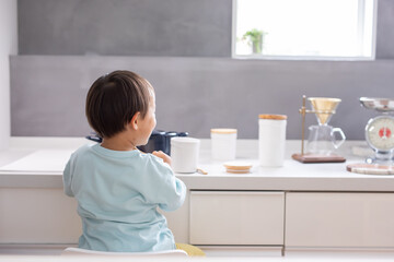 白いキッチンで男の子が青い鍋で料理をしている　boy kitchen 