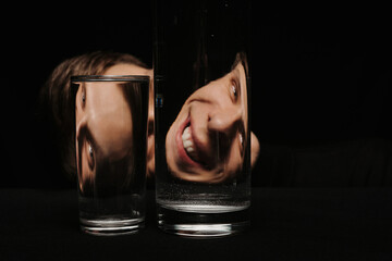 portrait of a smiling man looking through two glasses