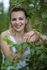 Portrait of a beautiful blonde girl with a wide smile in the park.