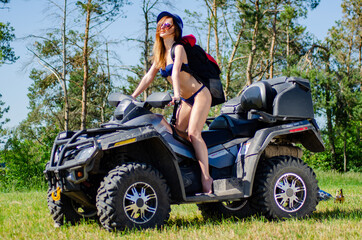 Fototapeta na wymiar Sexy, slim, pretty, attractive girl in swimsuit on the ATV quad bike. ATV concept.