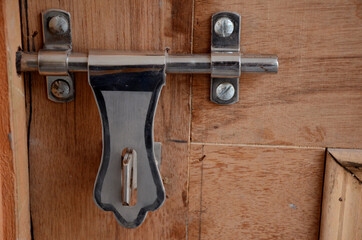 the silver color door lock on the with brown door.