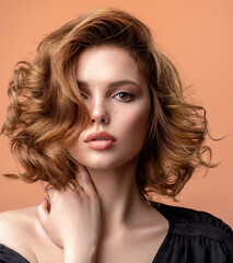 Beautiful brown haired with stylish short hairstyle. Woman with a  curly hair. Beautiful young woman with freckles on face.  Closeup portrait of an attractive girl  with a brown makeup.
