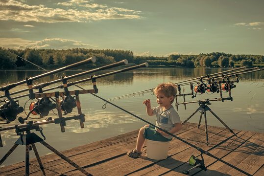 Kid fishind. Angling child with fishing rod on wooden pier.