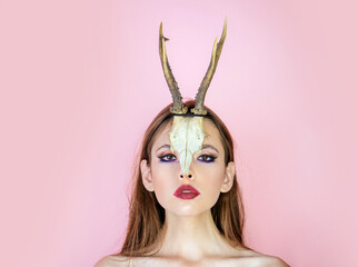 Young witch. Woman witch, halloween. Beauty of woman with animal skull and antlers.
