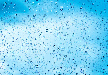 Fototapeta na wymiar Water drops or Rain drops on glass with blue filter