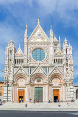 Duomo di Siena Cathedral with tourists on the stairs in Siena, Italy