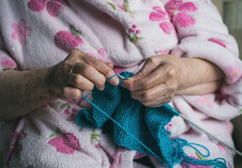 Close-up Of The Hands Of An Old Woman Weaving. Elderly Person Doing Chores.