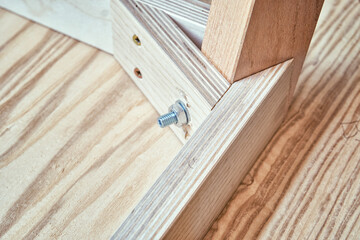 Corner of upside-down stylish new table of plywood, veneer and solid light ash in modern carpentry workshop extreme close view