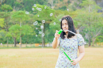 Beautiful women blowing bubbles having fun in the meadow