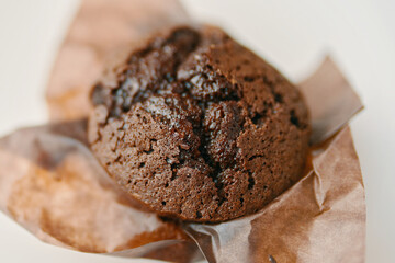 Chocolate muffin close up. Cupcake with dark chocolate in paper wrapper. Delicious dessert.