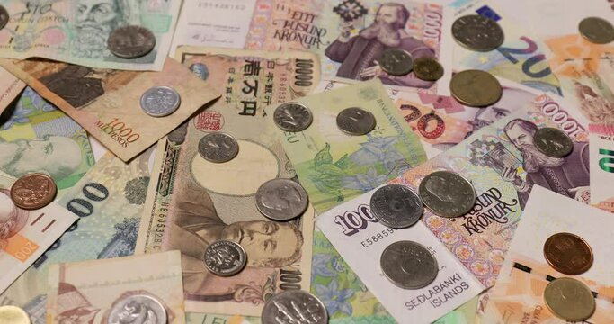 Currencies from around the world, collage of banknotes and coins, panning camera motion