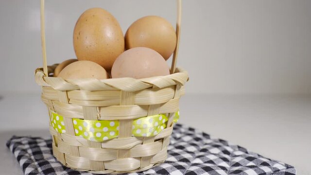 Putting an egg into a basket full of eggs, concept of the classic American proverb Never put all your eggs in one basket. Idea of financial risks