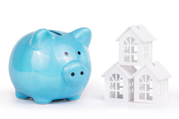 Savings for buying a house. Piggy bank and house on white background