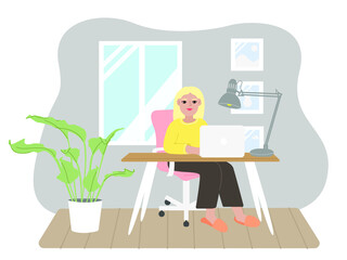 The blonde girl works at the computer in the room. Freelance woman at home.