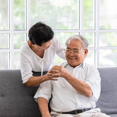 Obraz premium Senior old Asian man and woman lovers holding a glass of milk and drinking together. Idea for the healthcare of elder people