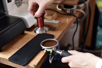 Fototapeta na wymiar Filter holder filled with freshly ground coffee. Espresso accessory.