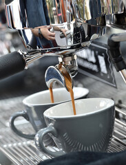 Espresso. Detail of coffee flowing from a professional espresso machine.